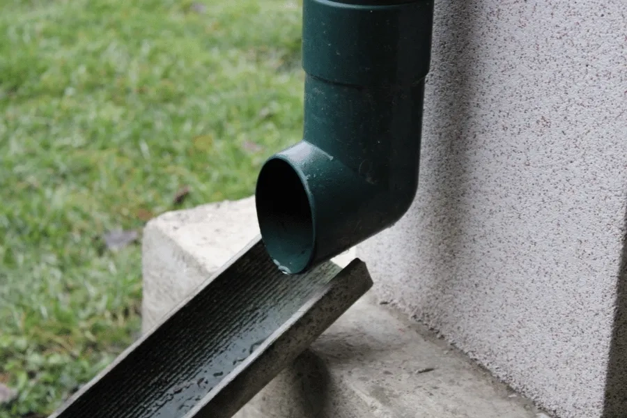 Precision Gutters LLC black gutter downspout installed beside home exterior