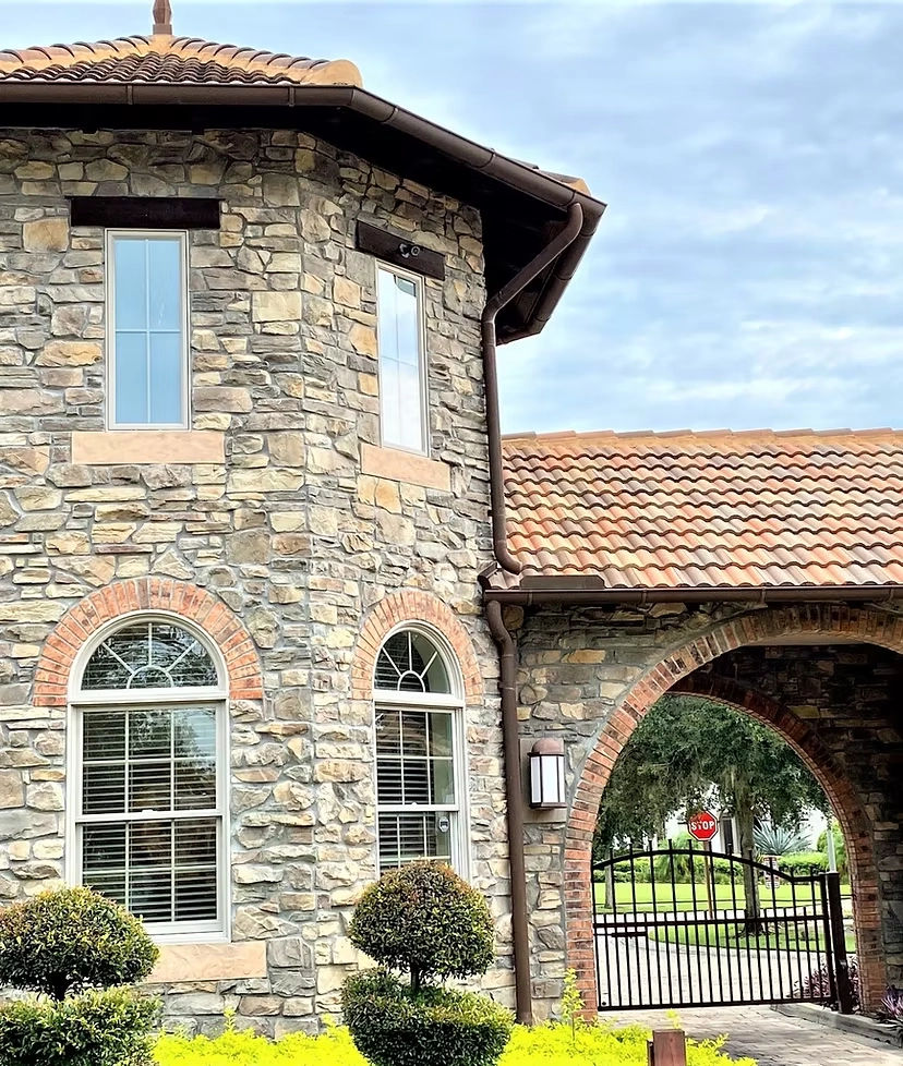 Luxury stone home with custom bronze gutter and downspout system installation