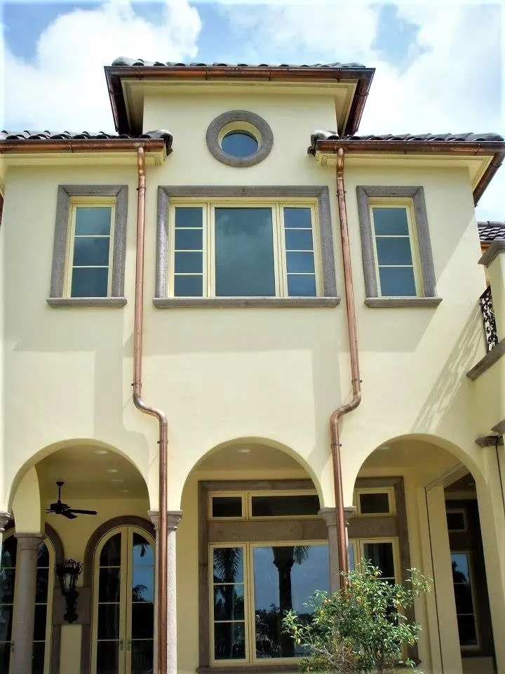 Custom copper gutter and downspout system installed on luxury residential home exterior