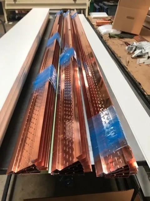 Custom copper gutter materials and trim pieces ready for fabrication