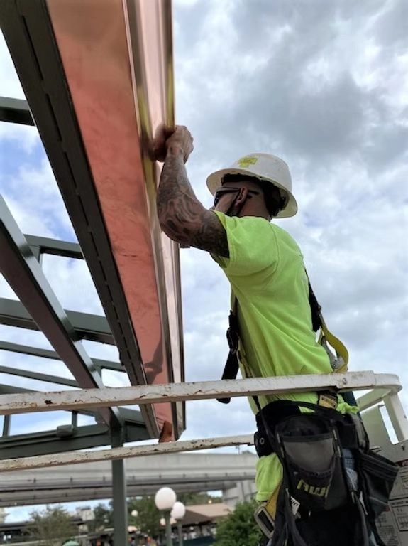Precision Gutters technician installing copper gutter system on commercial structure