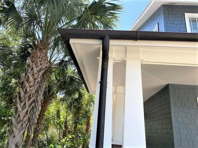Black seamless gutter and downspout installation on coastal-style residential home