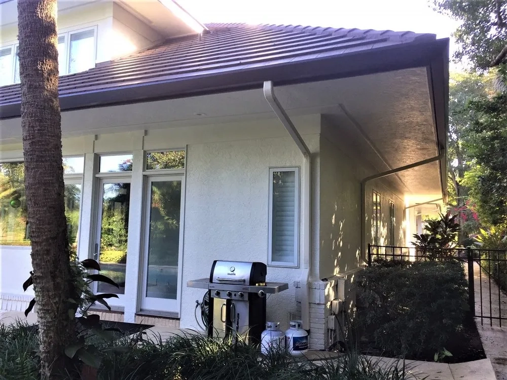 Black seamless gutter system installed on residential patio and roofline