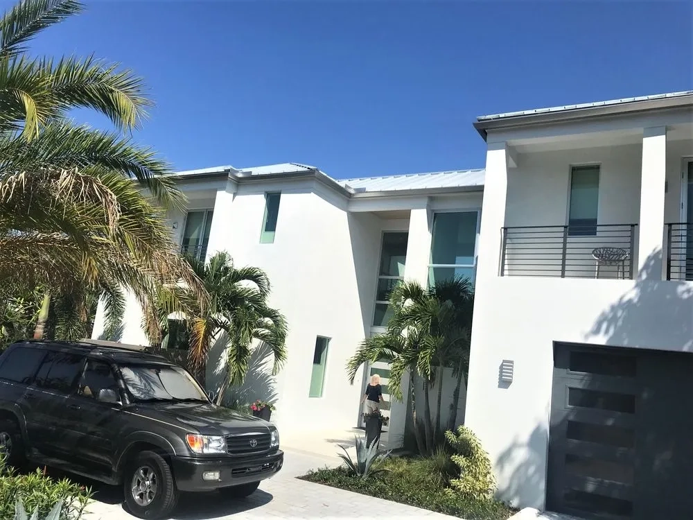 Modern white luxury home with seamless gutter system installation