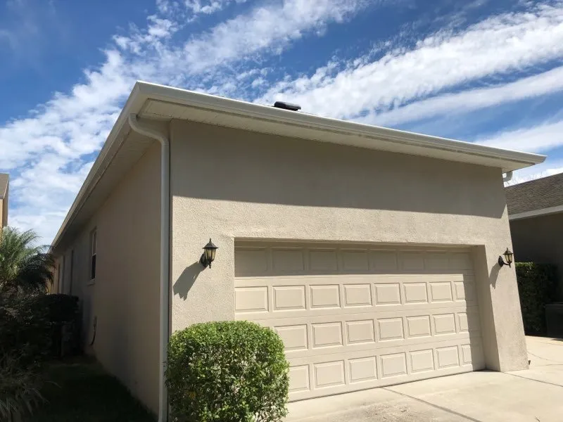 White seamless gutter system installed on residential garage exterior
