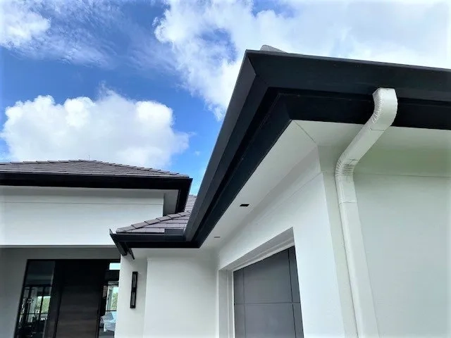 Precision Gutters FL seamless gutter installation showcasing black gutters and white downspouts on a Florida residence.