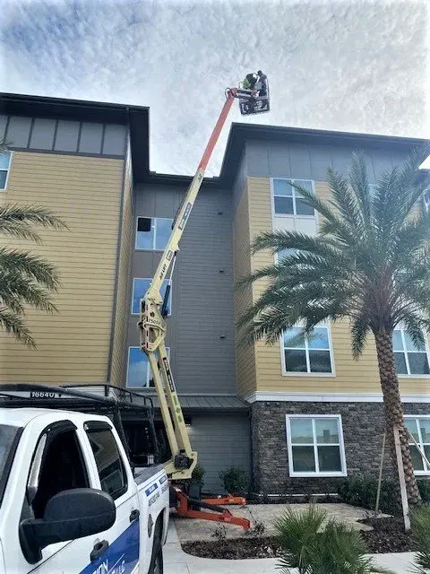 Commercial gutter installation using lift equipment on multi-story building