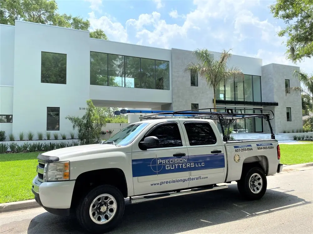 Precision Gutters LLC service truck parked in front of a modern residential home
