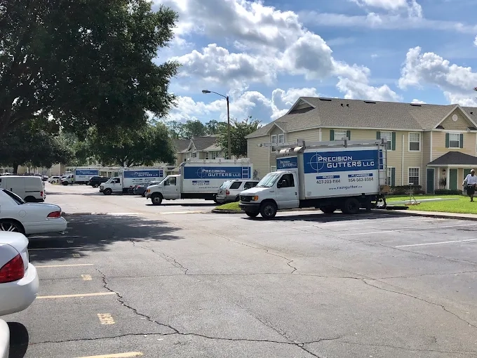 Precision Gutters FL service trucks parked at a Florida job site, showcasing the company's professional gutter installation team and residential rain gutter services throughout Central Florida.