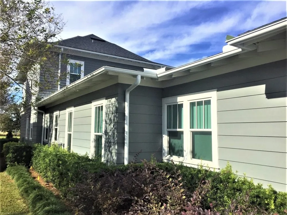 White seamless gutter installation on modern gray residential home